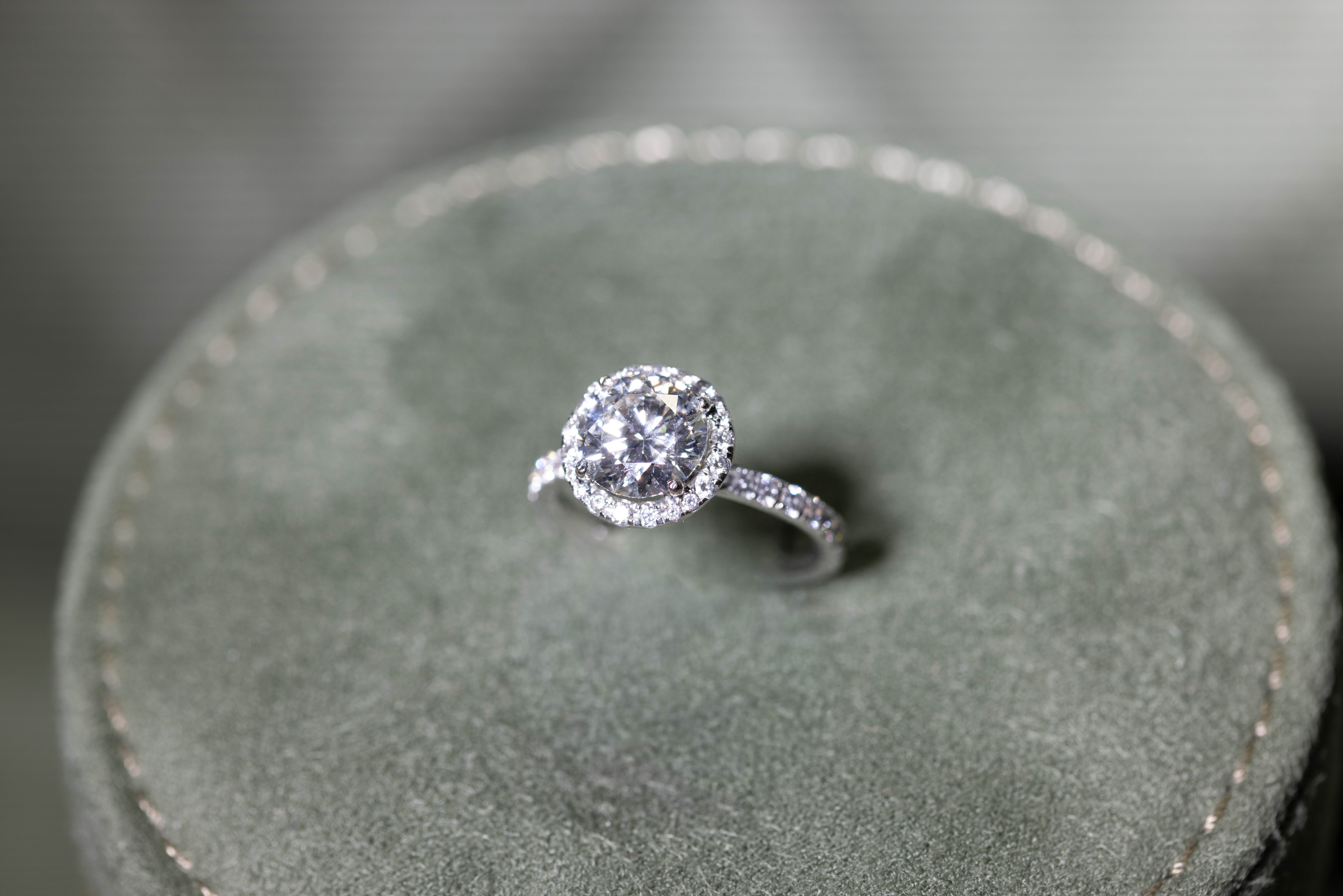 Round stone ring displayed on a jewellery cushion