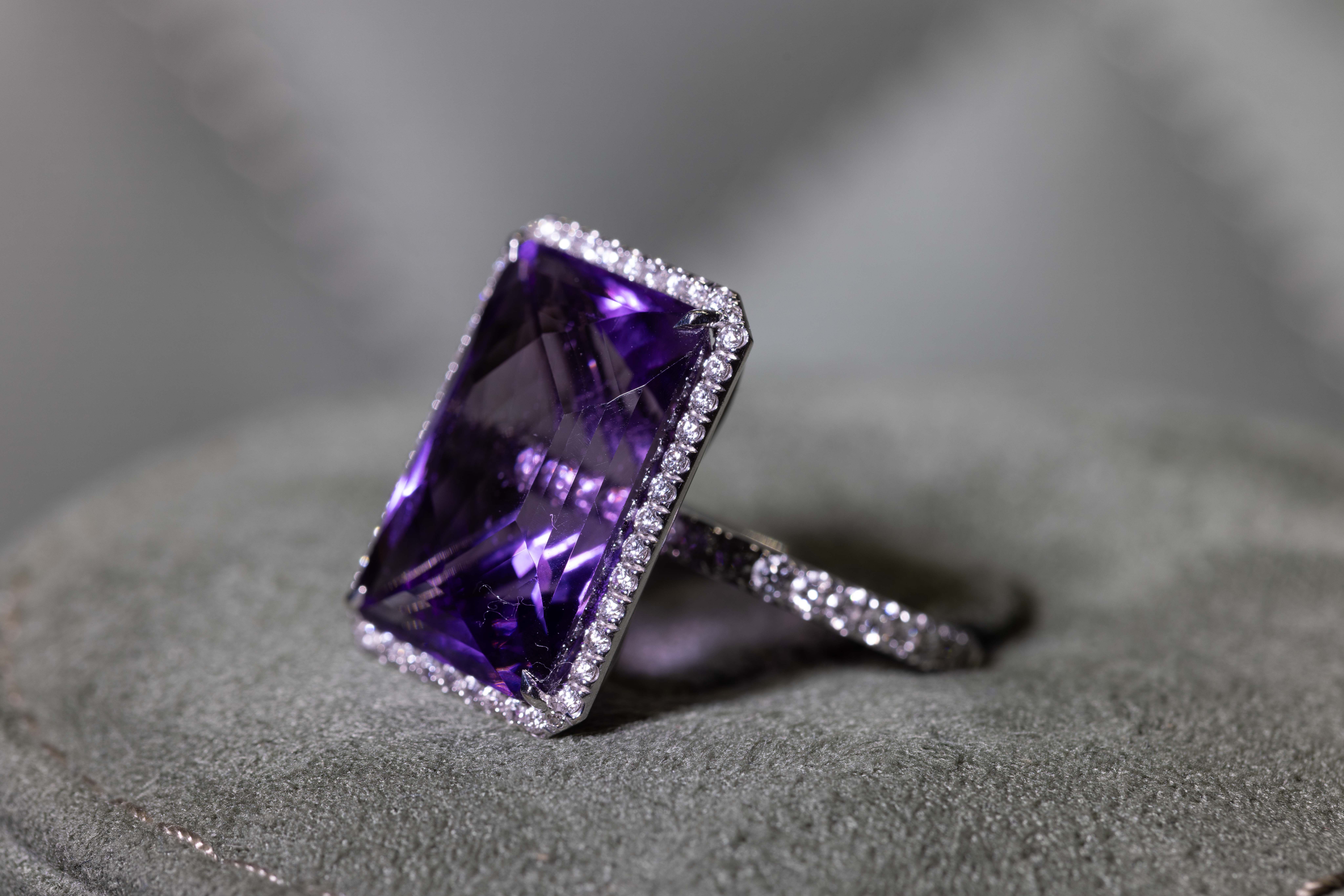 Purple stone ring displayed on a jewellery cushion
